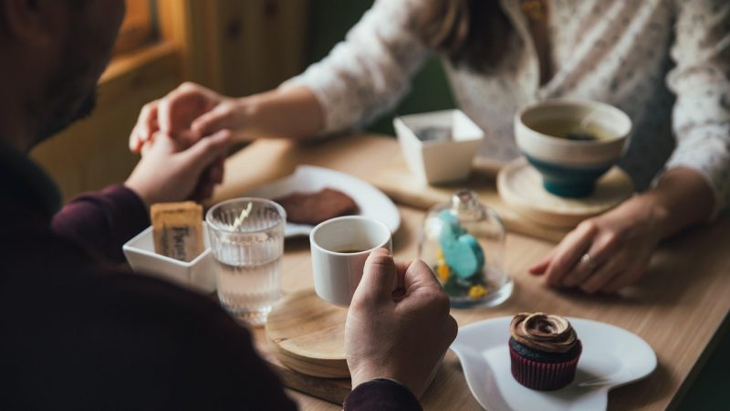 Two cups of coffee and a dessert on a café table